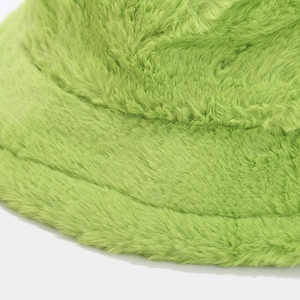 Macro shot of grass green plush bucket hat showing thick faux fur texture and brim stitching