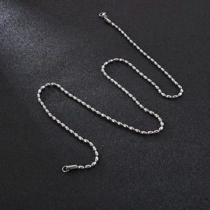 Unisex stainless steel silver ball chain necklace displayed on a textured black surface