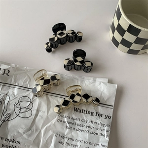 Minimalist checkerboard hair clips set in black and white with elegant gold trim accents