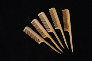 Set of five natural green sandalwood fine-tooth combs with long pointed handles on black back