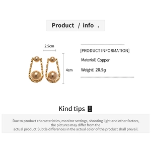 Detalle de pendientes en forma de U chapados en oro de 18K con esfera y textura relieve