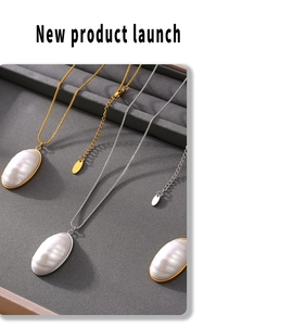 Detailed view of oval mother-of-pearl pendants on gold and silver box chain necklaces