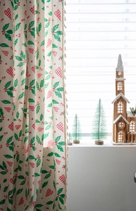 Detail of Christmas curtain featuring holly leaves and beige pompom fringe decor
