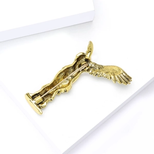 Detailed close-up of golden winged goddess brooch showing back pin and secure clasp mechanism