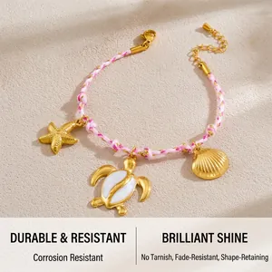 Macro detail of woven pink rope bracelet with golden sea turtle and starfish charms