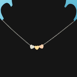 Detailed view of triple heart pendant necklace in silver, gold, and rose gold on a bust