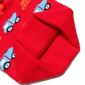 Detail shot of red knit kids hat showing excavator pattern and inner stitching texture