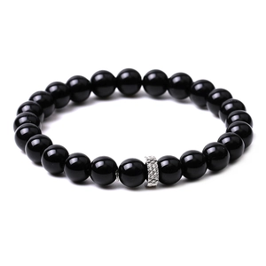 Detailed macro view of matte black agate beads with an engraved silver metal spacer bead