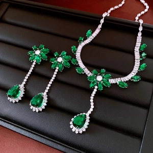 Détails macro d'une parure bijoux fleur émeraude avec des glands étincelants
