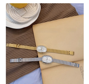 Close-up of vintage oval gold and silver women's quartz watches on a cozy knit fabric background