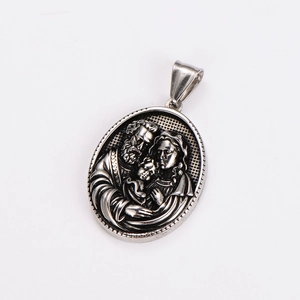 Macro detail of vintage embossed family pendant with silver finish on white background