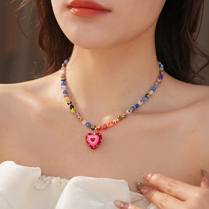 Colorful glass beaded necklace with heart pendant shown on a model neck