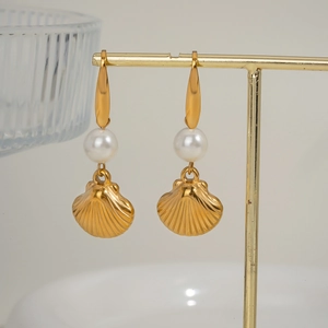 Elegant gold shell earrings with pearl drop charms displayed on a professional T-stand