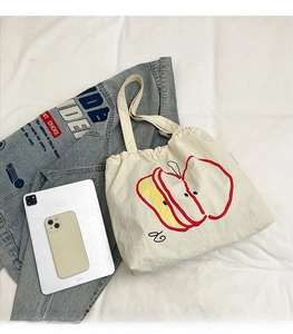 Top view of cream canvas tote bag showing interior capacity compared with iPad and phone
