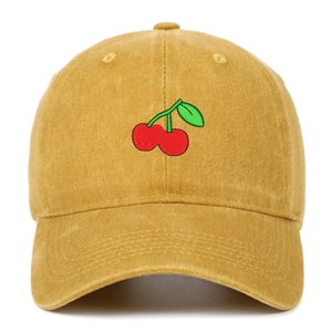 Close-up of cherry embroidery on mustard yellow washed cotton baseball cap texture