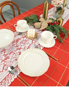 Detailed overhead view of a white lace table runner with intricate floral patterns