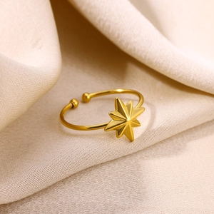 Gros plan détaillé d'une bague étoile dorée réglable sur un élégant tissu de soie beige