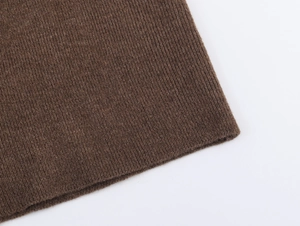 Detailed macro shot of deep brown ribbed knit fabric showing soft texture and quality weave