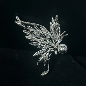 Vue arrière détaillée d'une broche papillon argentée avec fermoir et perles serties
