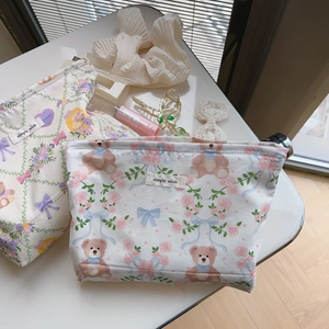 Floral canvas cosmetic bags with rose and bear prints styled with vanity accessories