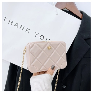 Close-up of pink jelly cross-body bag with diamond quilted pattern and gold flower buckle