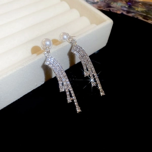 Detail shot of silver tassel earrings with white pearls and sparkling rhinestones
