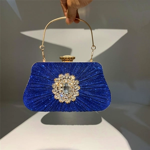 Detailed shot of royal blue evening clutch with pleated rhinestones and gold handle