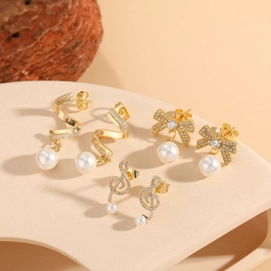 Three pairs of elegant gold pearl earrings with zircon bows and musical notes