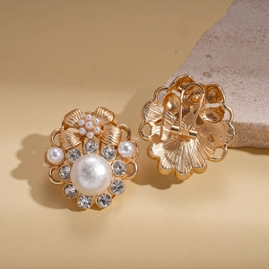 Detail of vintage gold flower earrings featuring pearls and sparkling rhinestones
