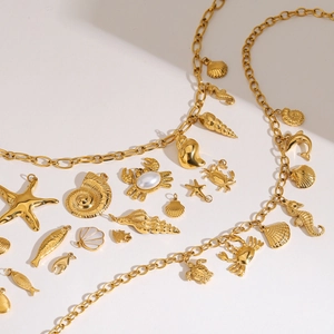 Collection of golden ocean-themed jewelry charms featuring starfish, shells, and turtles