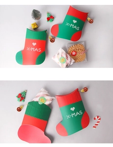 Detailed view of red and green Christmas stocking shaped paper gift bags with X-MAS cutout