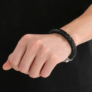 Detail of black double-layered braided leather bracelet with silver magnetic steel clasp