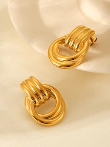 Detailed view of 18k gold plated stainless steel twisted earrings on a ceramic tray