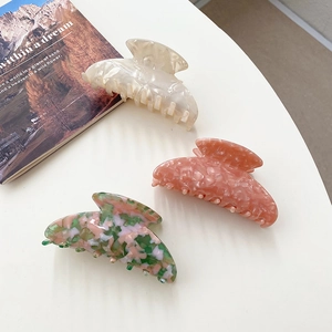 Vue détaillée de trois pinces à cheveux en acétate marbré aux tons pastel doux