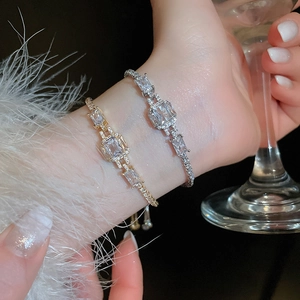 Close-up of luxury adjustable gold and silver bracelets with emerald cut zircon crystals