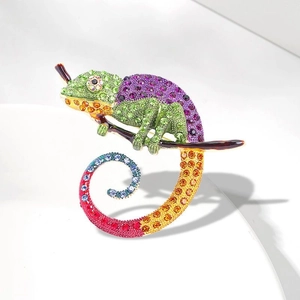 Macro shot of chameleon brooch with colorful rhinestones on polished gold finish