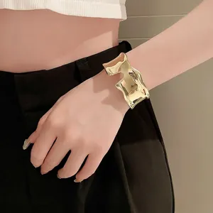 Exaggerated irregular gold open bangle with a modern textured lava design for women