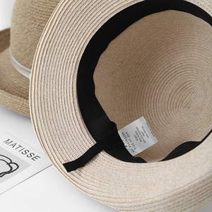 Détail d'un chapeau de paille montrant l'étiquette de lavage intérieure et la taille 57,5cm