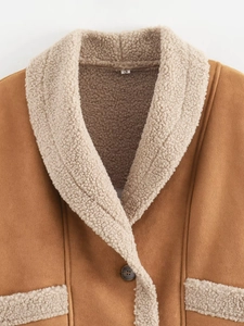 Nahaufnahme der braunen Wildlederjacke mit warmem Lammwollkragen und Knopfdetails