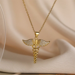 Dettaglio di un ciondolo caduceo dorato con ali decorate da cristalli brillanti