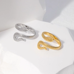 Macro shot of gold and silver snake rings on stone display showing metallic textures