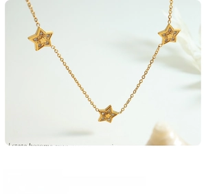 Macro shot of 18K gold plated star pendants with inlaid zircon on a delicate necklace chain