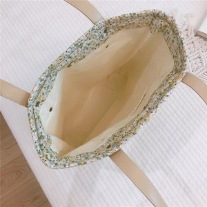 Top view of floral tote bag interior featuring zipper pocket and reinforced handles