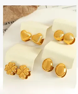 Vue macro détaillée de quatre paires de boucles d'oreilles dorées en trèfle et cœur