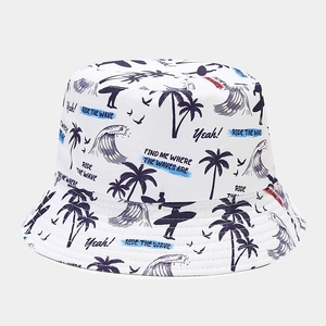 Détail d'un bob blanc avec imprimé de palmiers bleus et motifs de surf