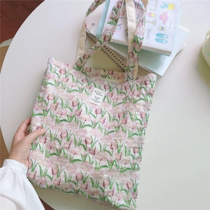 Detail einer Baumwolltasche mit Tulpenprint, gewebtem Etikett und breitem Gurt