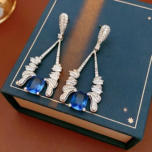 Detail of vintage silver drop earrings with blue gemstones on a jewelry box lid
