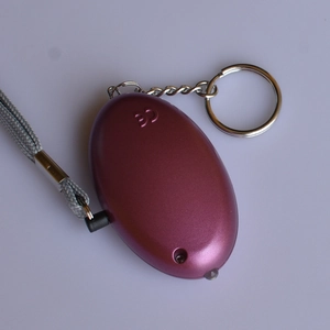 Macro shot of purple personal alarm back with CE certification mark and LED light