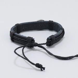 Détail d'un bracelet multicouche en cuir noir tressé avec fermeture à cordon réglable
