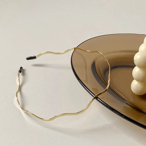 Minimalist wavy golden metal headband for women on elegant white and amber setting